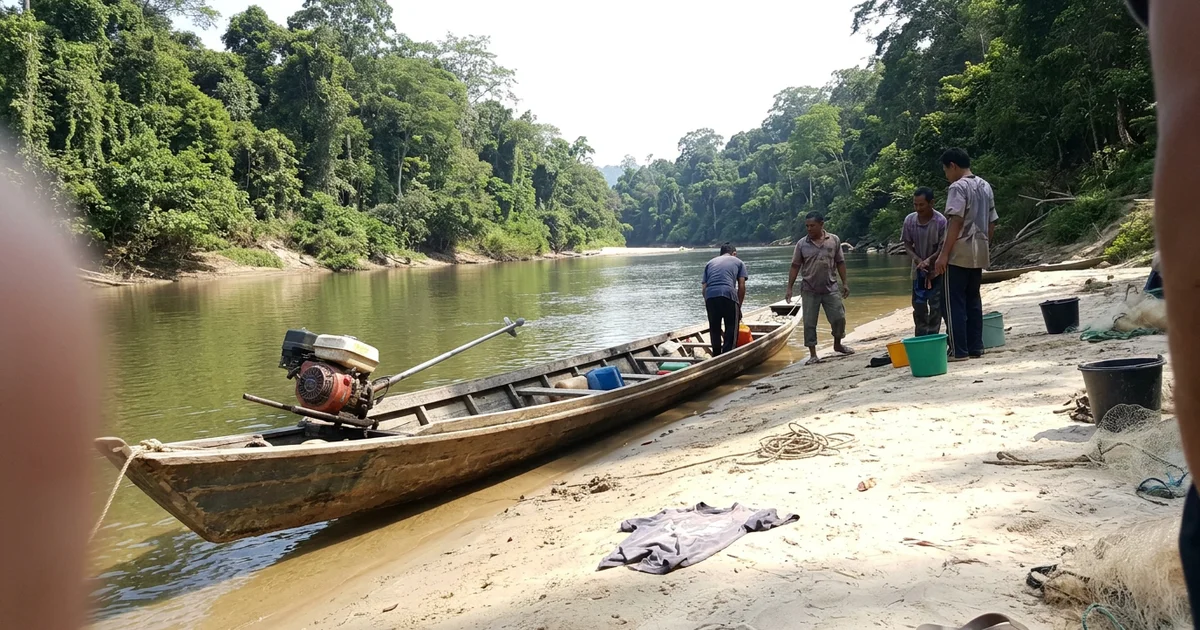 The Tembeling river under bright dry-season light with green banks and a moored longboat