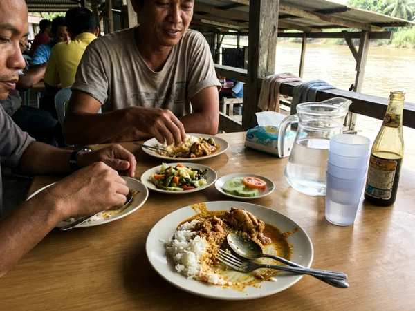 A simple local Malaysian lunch served at a riverside table